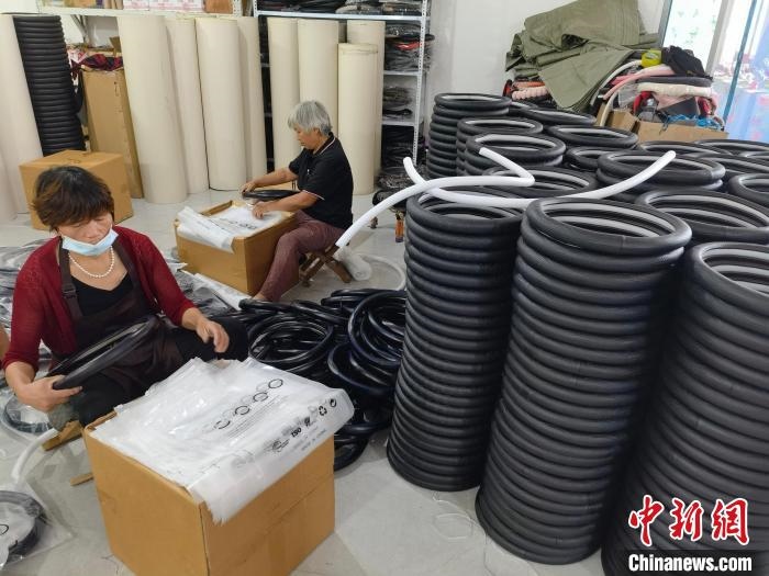 圖為村民在汽車飾品企業(yè)生產(chǎn)車間中工作?！巫雍?攝