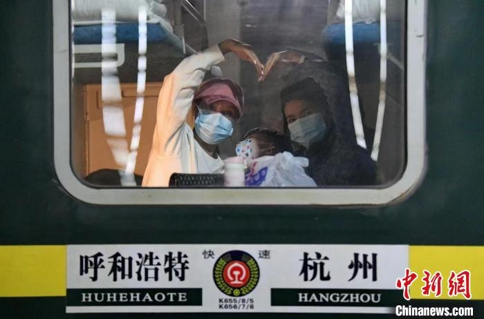 圖為登上轉(zhuǎn)運(yùn)火車的游客向額濟(jì)納比心?！⊥趵?攝