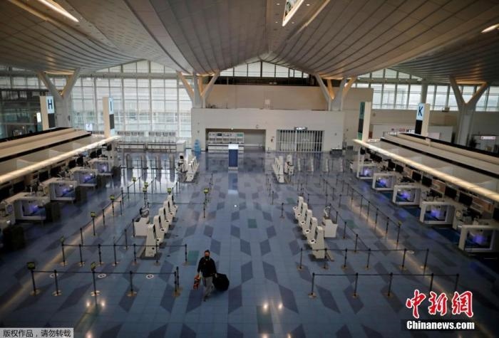 資料圖：日本東京，東京國際機場，一名乘客在國際航班航站樓的登機區(qū)。