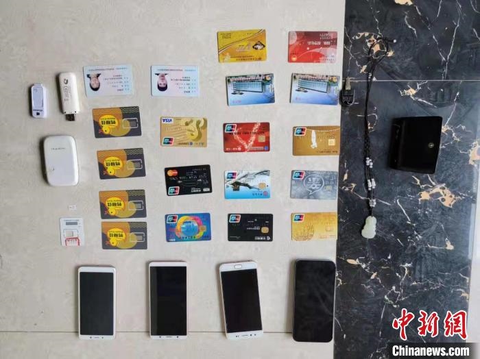 資料圖為果洛藏族自治州公安民警查扣的作案手機(jī)和涉案銀行卡?！‖斍呖h公安局供圖