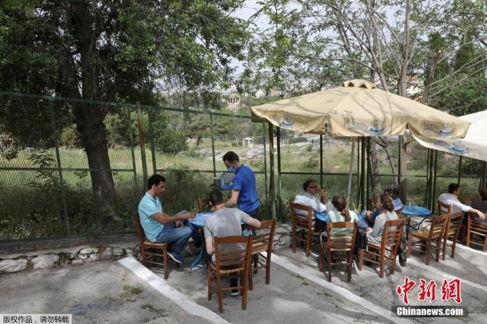 資料圖：希臘雅典，人們在一家露天咖啡享用飲品。