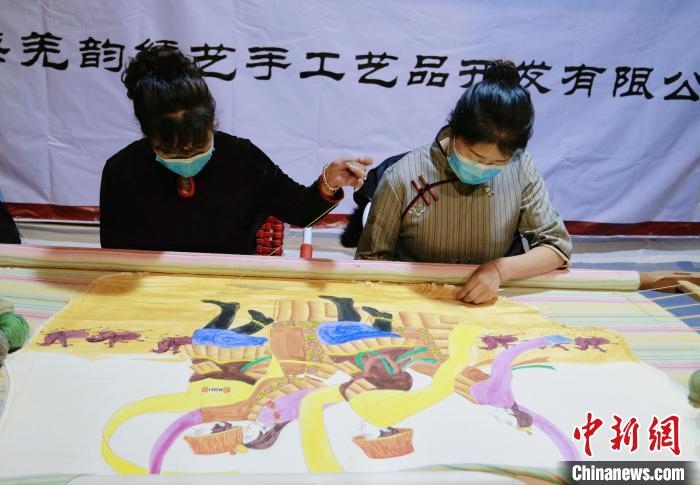 圖為皮繡藝人在市集上“秀”指尖技藝?！●R銘言 攝