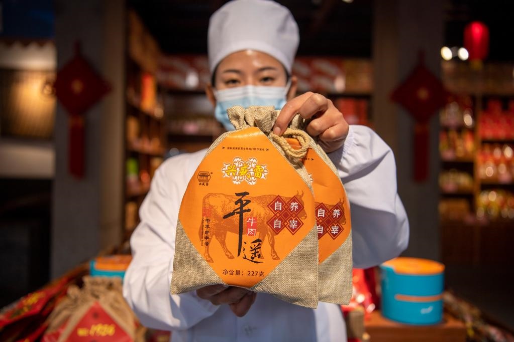 1月27日，在平遙古城南大街的一家平遙牛肉店內(nèi)，工作人員展示一款牛肉產(chǎn)品。新華社記者 楊晨光 攝