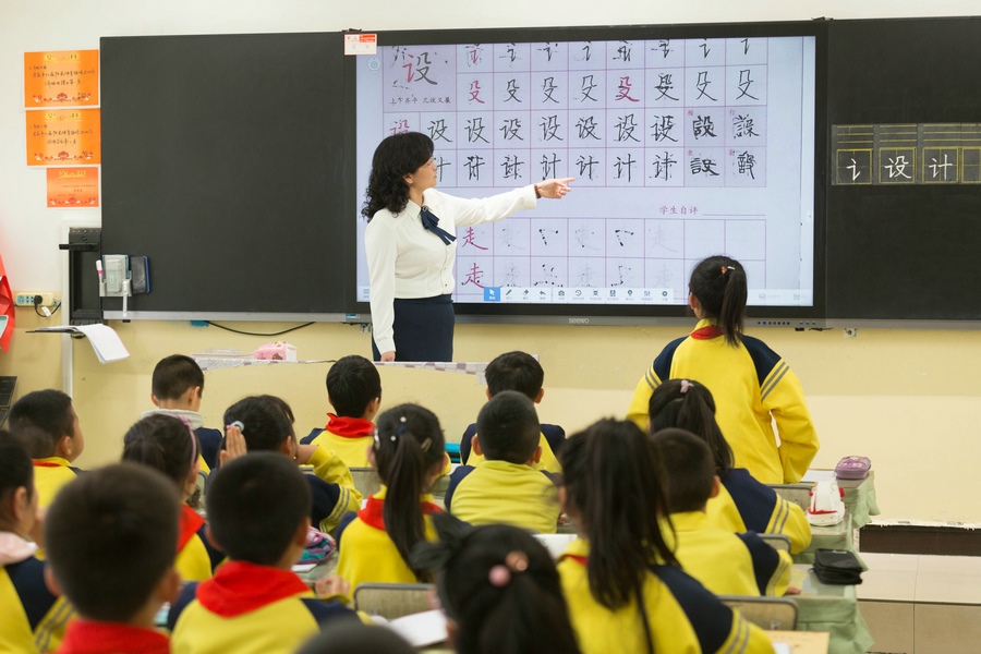 民族路小學（迎賓校區(qū)），語文老師燕凌云與學生們共同評議同學書寫的漢字.jpg
