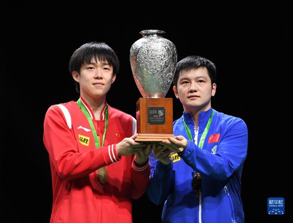 5月27日，樊振東（右）/王楚欽在頒獎儀式上高舉獎杯慶祝。當日，在南非德班進行的2023年世界乒乓球錦標賽男雙決賽中，中國組合樊振東/王楚欽以3比0戰(zhàn)勝韓國組合張禹珍/林鐘勛，奪得冠軍。新華社記者 李亞輝攝
