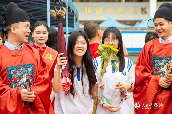 6月7日上午，在南寧市天桃實(shí)驗(yàn)學(xué)校翠竹校區(qū)，老師們?cè)跒榭忌鷤兗佑凸膭?！人民網(wǎng)記者 嚴(yán)立政攝