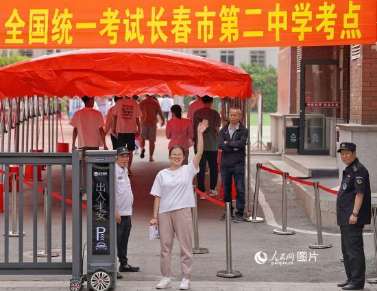 6月7日，在長(zhǎng)春市第二中學(xué)考點(diǎn)，一名考生信心滿滿進(jìn)入考場(chǎng)，并與家長(zhǎng)揮手致意。人民網(wǎng)記者 李洋攝
