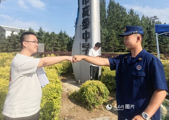 6月7日，遼寧營(yíng)口老邊區(qū)消防救援大隊(duì)的消防員為高考學(xué)子加油助威。人民網(wǎng)記者 尹柏寒?dāng)z