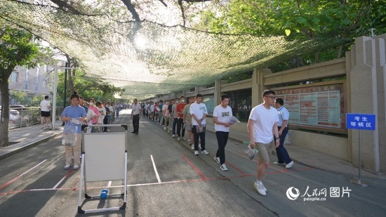 6月7日，烏魯木齊市第七十中學(xué)門口，考生們有序進(jìn)入考場(chǎng)。人民網(wǎng) 李欣洋攝