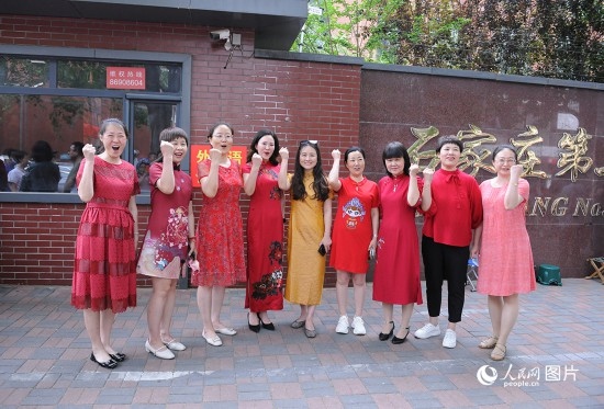 6月7日，在石家莊第二十七中學(xué)考點(diǎn)，家長(zhǎng)身著旗袍，為高考的孩子們加油助威！紅紅火火、旗開得勝！人民網(wǎng)記者 周博攝