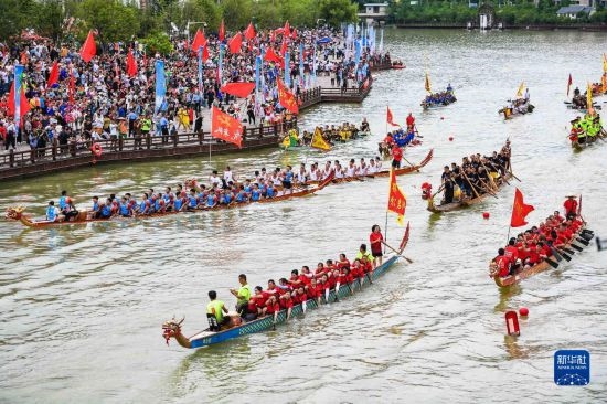 6月23日，在貴州省黔東南苗族侗族自治州施秉縣舉行的獨(dú)木龍舟節(jié)上，獨(dú)木龍舟進(jìn)行水上巡游。