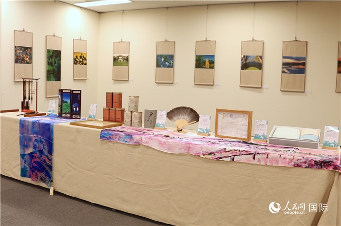 現(xiàn)場(chǎng)展出的馮學(xué)敏攝影作品與湖州市特色工藝品。（人民網(wǎng) 許可攝）