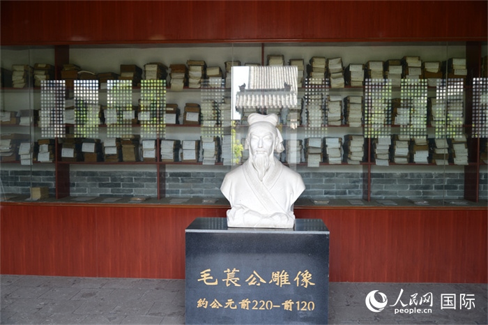河間詩經(jīng)齋毛萇雕像。雕像后書櫥中陳列的是歷代各版本《詩經(jīng)》及譯本。 人民網(wǎng) 趙昭攝