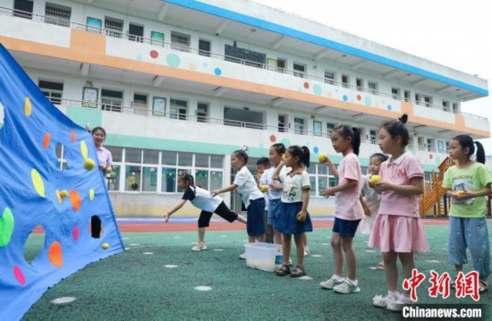 在肥西縣山南鎮(zhèn)中心幼兒園，孩子們在玩布洞投球游戲。陳家樂 攝