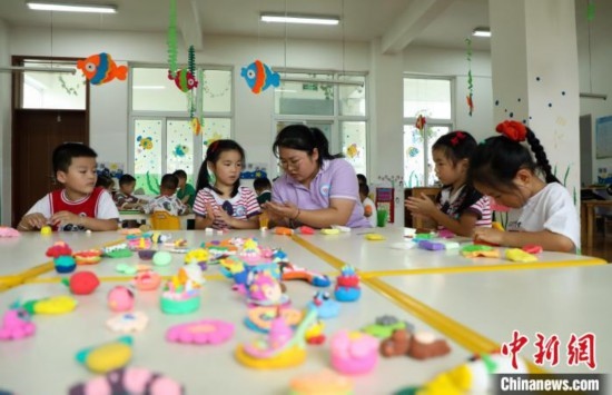 在肥西縣山南鎮(zhèn)中心幼兒園，孩子們在老師的指導(dǎo)下做彩色泥塑。陳家樂 攝