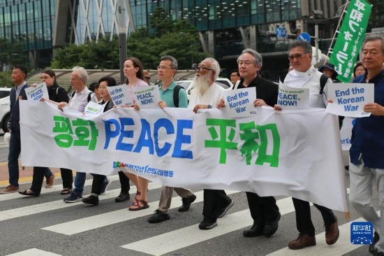 7月22日，在韓國首爾，人們手舉標(biāo)語參與反戰(zhàn)游行。新華社發(fā)（楊暢 攝）