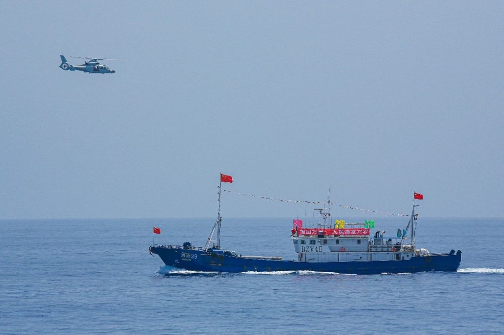 ↑中國海軍第40批護航編隊中的艦載直升機在被護船只周邊海域巡邏警戒（2022年6月4日攝）。新華社發(fā)（唐文 攝）