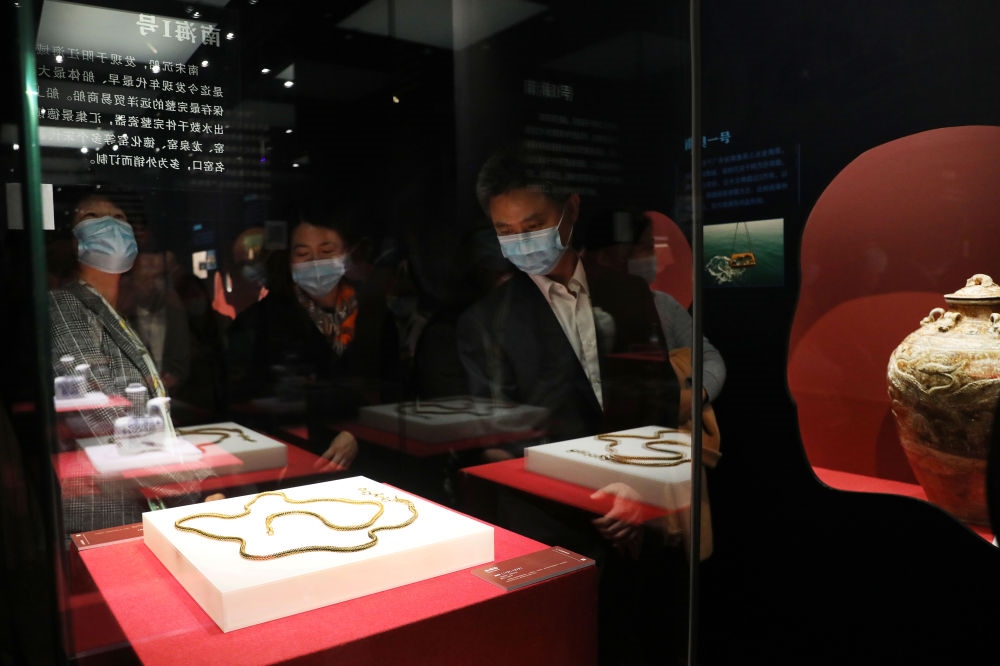 參觀者在上海臨港新城的中國航海博物館航海文物展上的“南海一號”出水的宋代金項飾展柜前駐足觀看（2020年12月28日攝）。新華社記者 方喆 攝