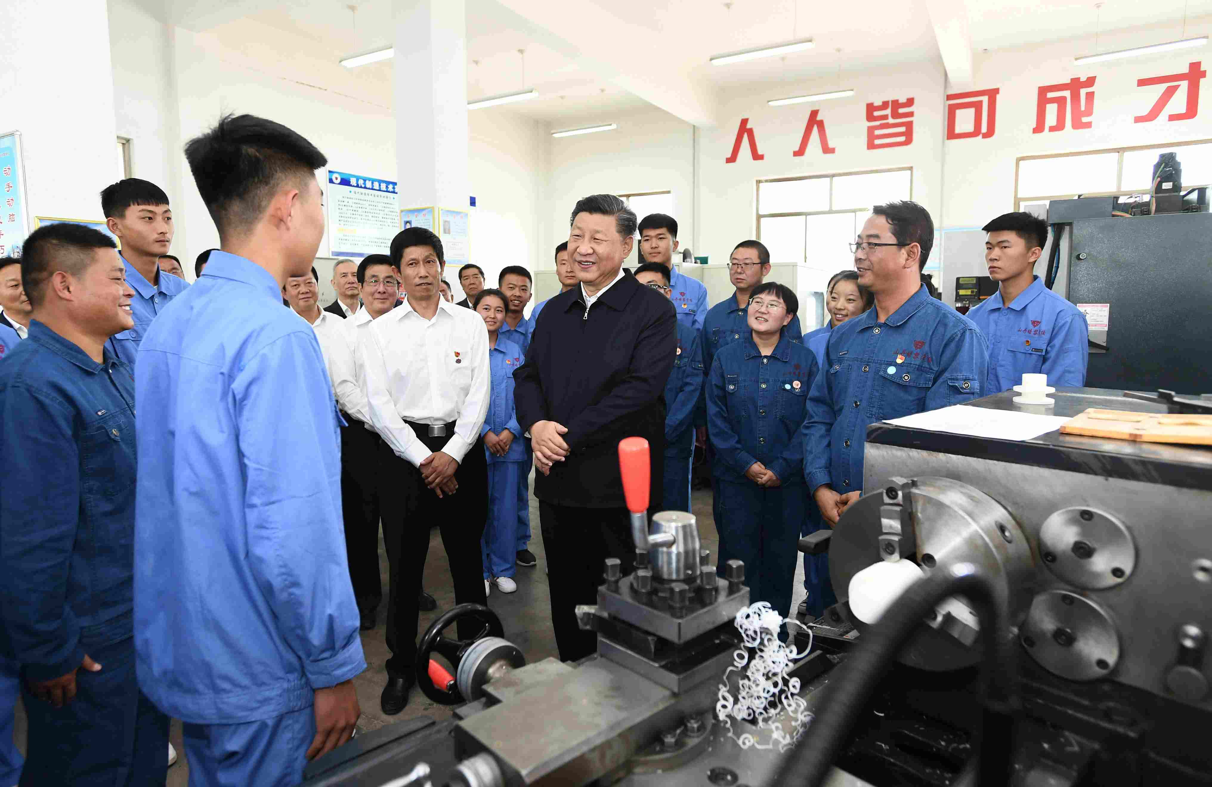 2019年8月20日，習(xí)近平在甘肅省張掖市山丹培黎學(xué)?，F(xiàn)代制造技術(shù)實(shí)訓(xùn)室，觀看職業(yè)技能實(shí)訓(xùn)，同師生親切交流。