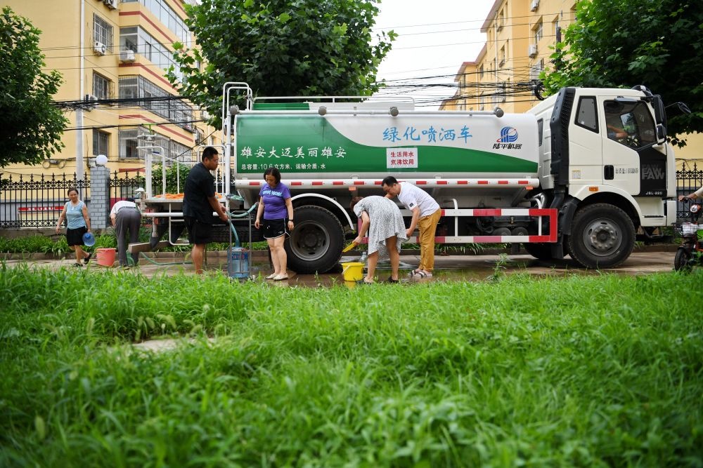 河北省涿州市新星小區(qū)居民從供水車?yán)锝铀?月4日攝）。新華社記者 牟宇 攝