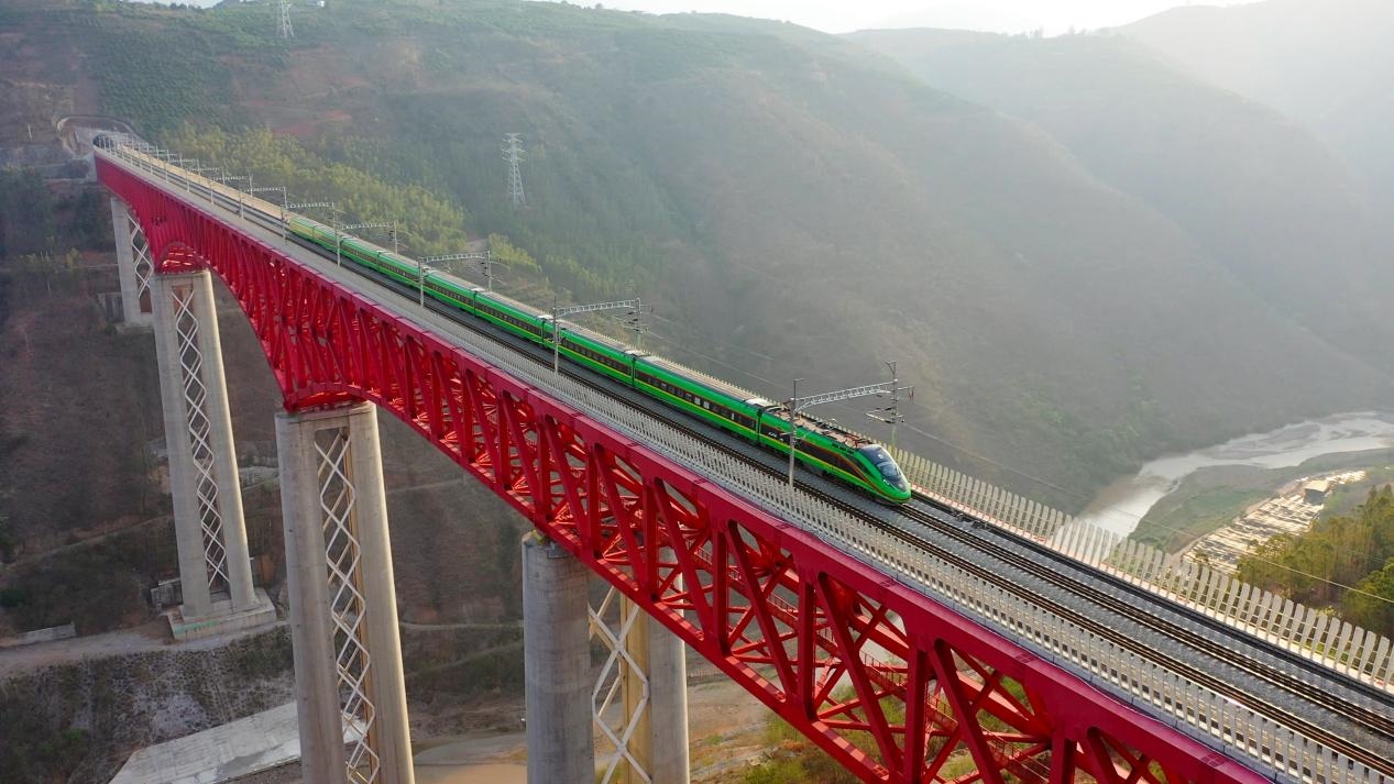 中老鐵路國(guó)際旅客列車在云南省境內(nèi)的元江特大橋上飛馳。姚巍攝