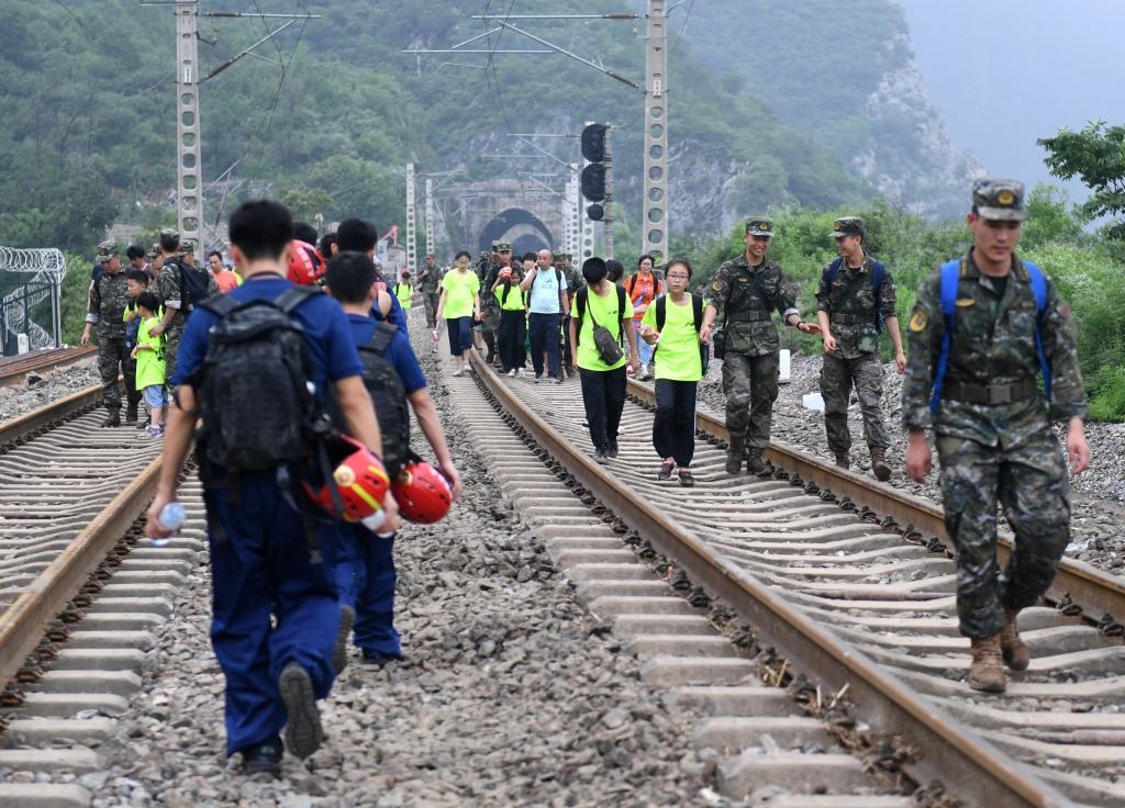 8月2日，部分滯留在北京市門頭溝山區(qū)受困列車的旅客，在救援人員幫助下前往轉(zhuǎn)運(yùn)客車。新華社記者張晨霖 攝