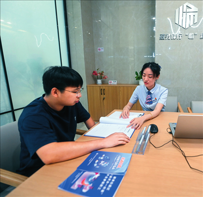 在杭州市臨安區(qū)政務(wù)服務(wù)中心的“為企服務(wù)中心”，黨員志愿者（右）解答企業(yè)主的疑問（2023年7月7日攝）。徐昱攝/本刊