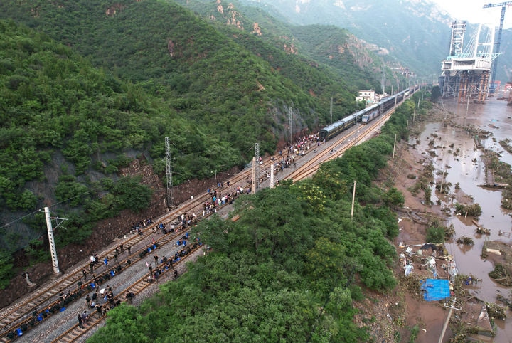 8月2日，受困列車旅客在救援人員幫助下徒步趕往轉(zhuǎn)運客車（無人機照片）。新華社記者 張晨霖 攝