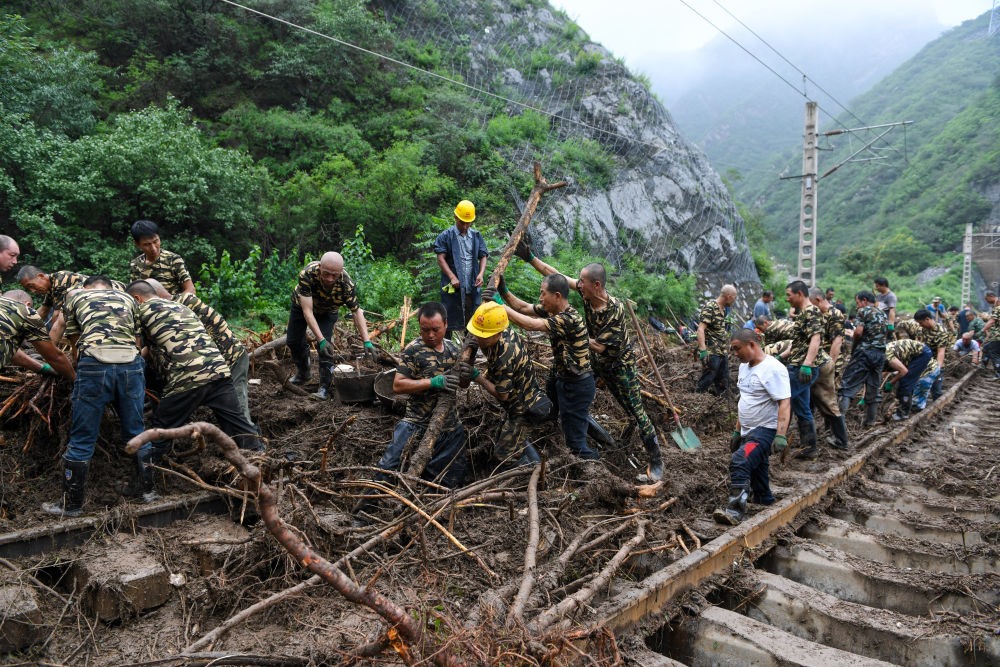 8月1日，在北京市門頭溝區(qū)水峪嘴村附近一段被阻斷的鐵路線上，中鐵六局工作人員在清理軌道上的雜物，全力恢復(fù)交通。新華社記者 鞠煥宗 攝