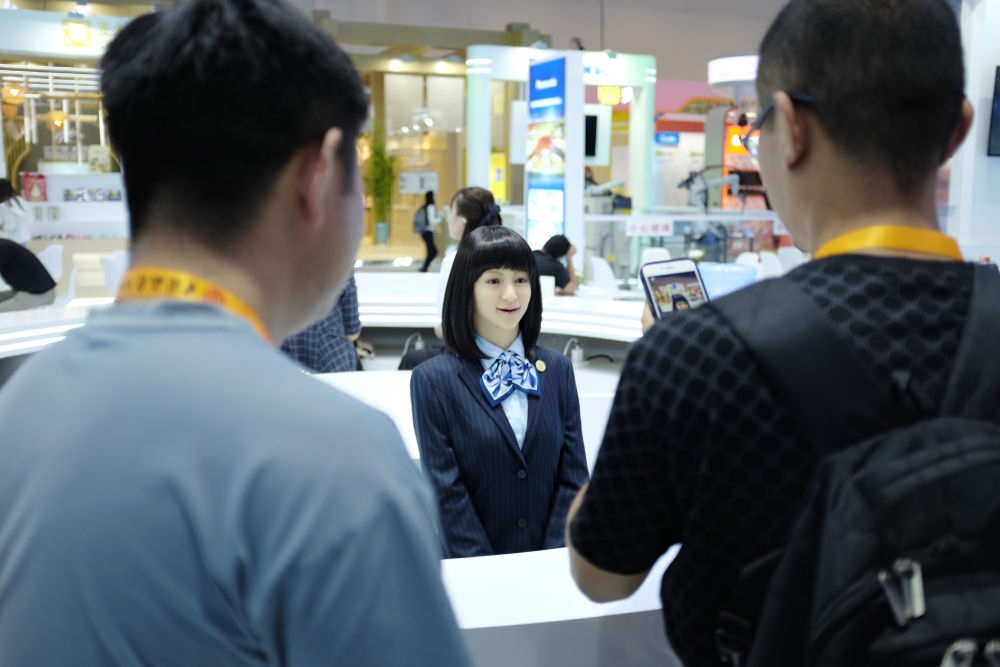 9月1日，媒體記者在國家會議中心與服務(wù)機(jī)器人互動。新華社記者 劉夢琪 攝