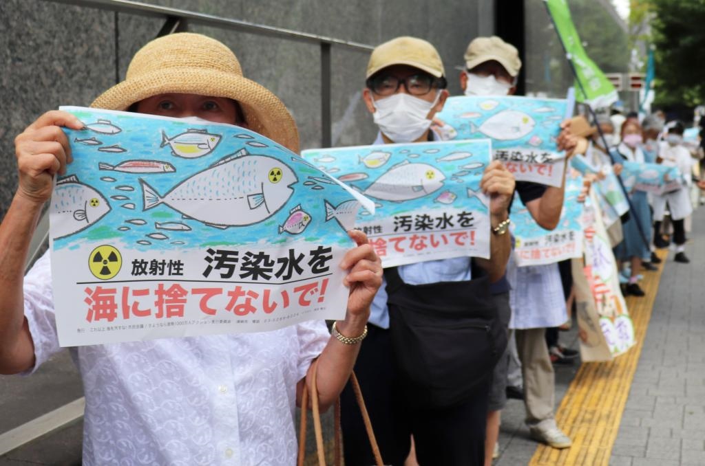 8月24日，日本民眾手持“不要將污染水扔進大?！钡葮苏Z在東京電力公司總部前集會，抗議日本政府和東電公司無視民意啟動核污染水排海。新華社記者楊光攝