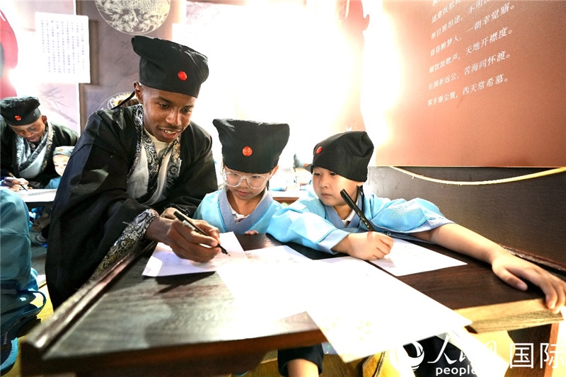 圖為選手與同學(xué)們一起寫書(shū)法。人民網(wǎng) 盧鵬宇攝