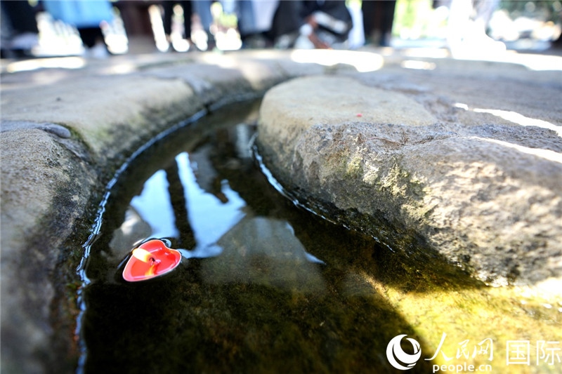 圖為水渠里流過(guò)的“桃心”蠟燭。人民網(wǎng) 盧鵬宇攝