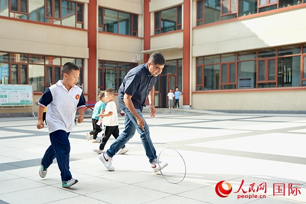 來(lái)自巴基斯坦的沙杰在滾鐵環(huán)。人民網(wǎng) 盧鵬宇攝