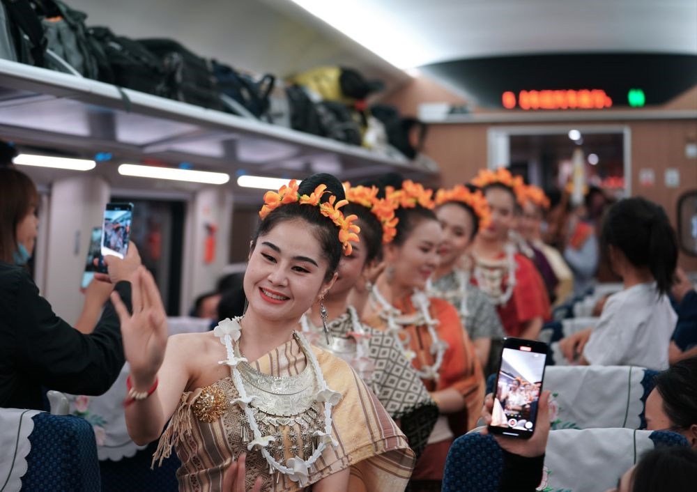 2023年4月13日，老撾工作人員在中老鐵路上開行的D887次國際旅客列車上表演。新華社記者 邢廣利 攝