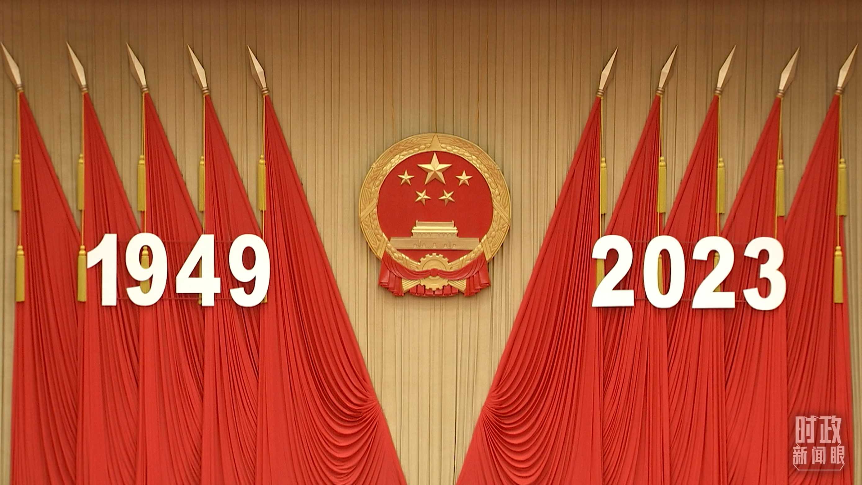 △人民大會(huì)堂宴會(huì)廳內(nèi)，主席臺(tái)上方高懸著莊嚴(yán)的國(guó)徽，“1949－2023”大字年號(hào)在鮮艷的紅旗映襯下格外醒目。