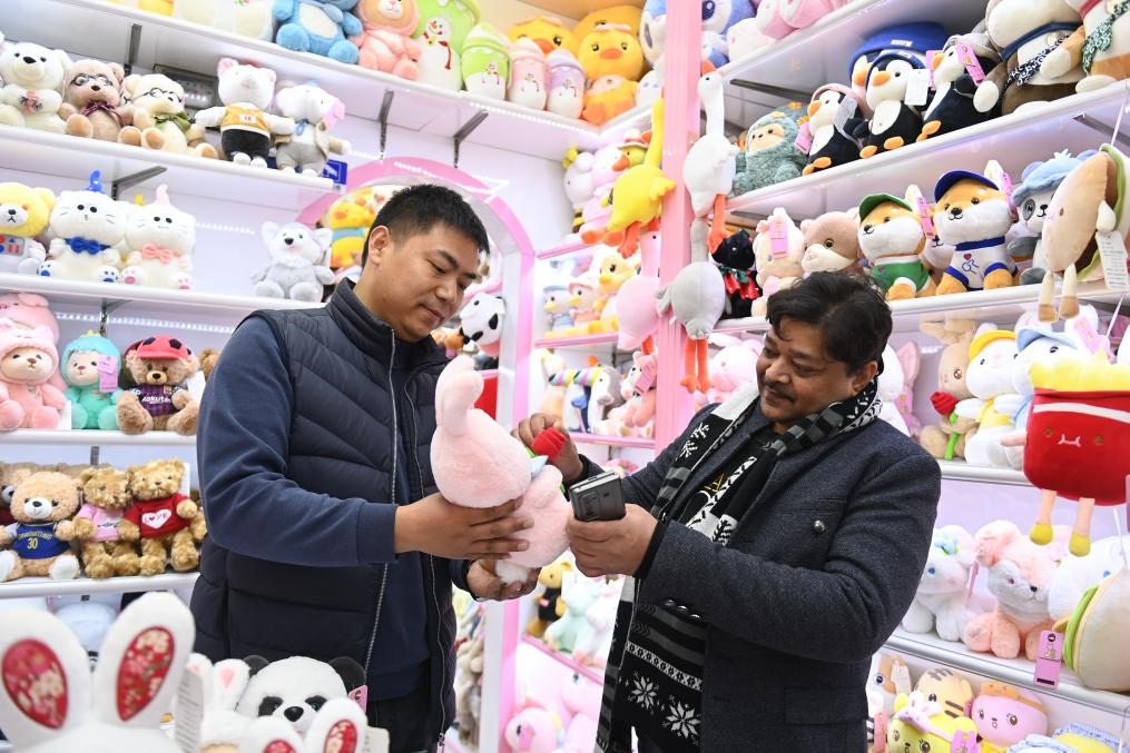 2023年2月2日，來自印度的客商（右）在義烏國際商貿(mào)城的一家玩具店鋪內(nèi)選購商品。新華社記者 黃宗治 攝