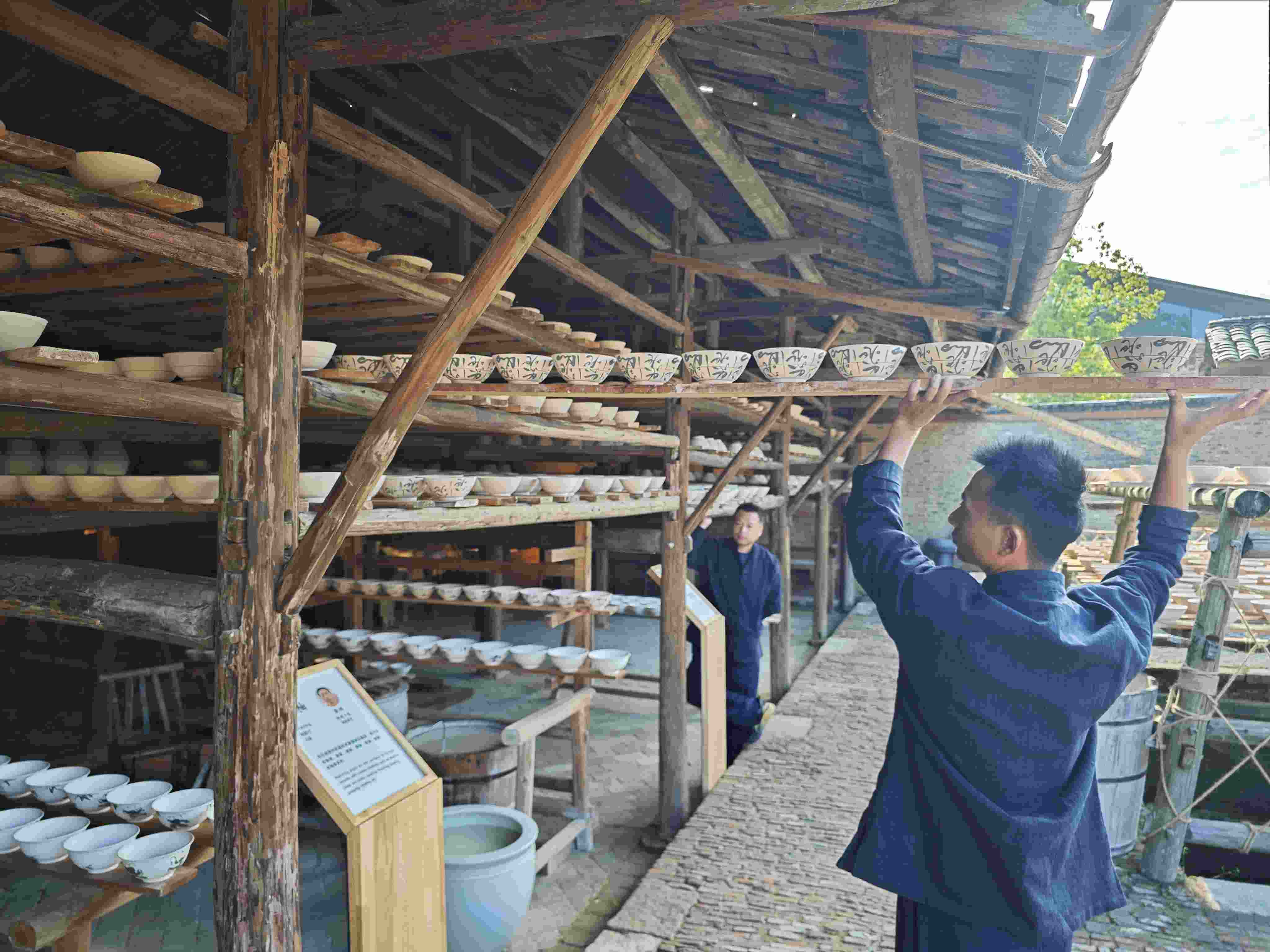 △陶陽里歷史文化街區(qū)里，工匠將陶瓷工藝品放到架上晾干。（總臺央視記者彭漢明拍攝）