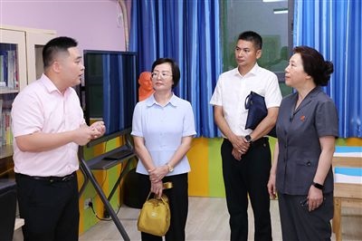 圖③：“小公民法律課堂”開講前，全國人大代表殷其龍（右二）、重慶市人大代表李自玲（左二）聽取楊家坪中學(xué)負(fù)責(zé)人關(guān)于未成年人思想教育工作情況的介紹。