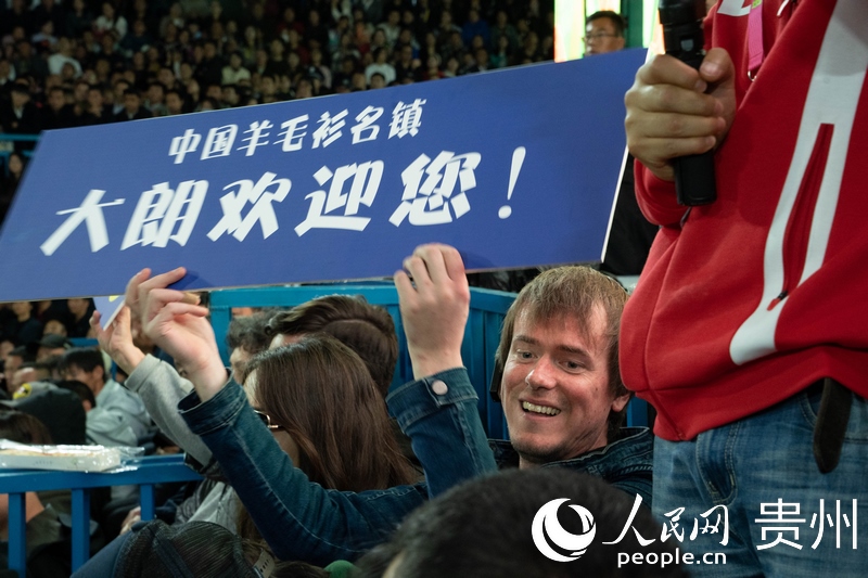 外媒記者舉起手牌為運(yùn)動員加油。人民網(wǎng) 陽茜攝