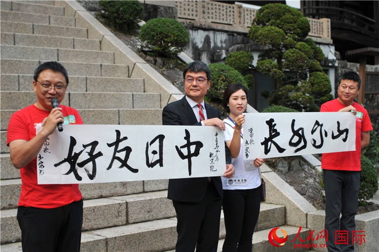 東京中國(guó)文化中心主任羅玉泉展示其為本次活動(dòng)書(shū)寫(xiě)的題詞“中日友好，山高水長(zhǎng)”。人民網(wǎng) 蔣曉辰攝
