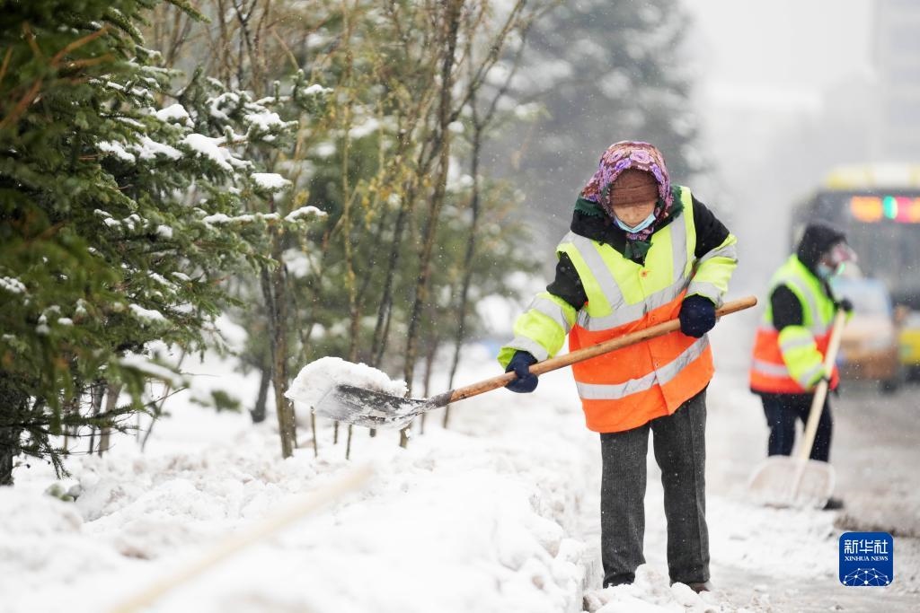 11月16日，環(huán)衛(wèi)工人在清理道路上的積雪。當(dāng)日，黑龍江哈爾濱市迎來雨雪天氣。新華社記者 王建威 攝