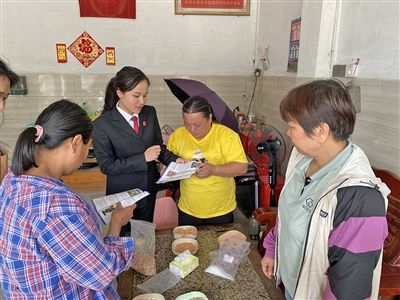  圖⑤：龍圩區(qū)法院法官到群眾家中開展法治宣傳。資料圖片