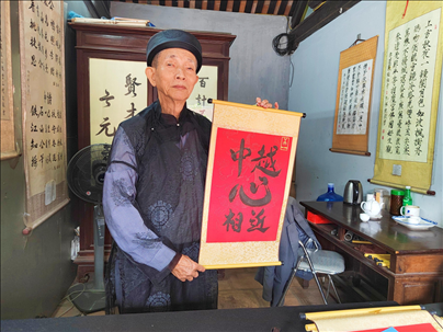 越南首都河內(nèi)文廟內(nèi)，阮明珠展示“中越心相近”書法作品。