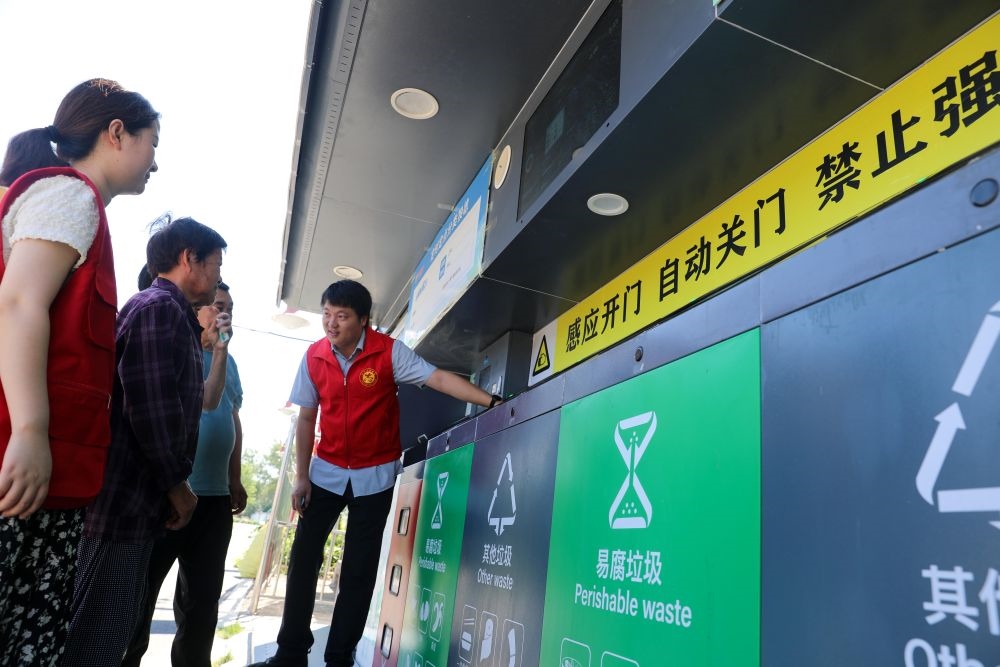 在安徽省合肥市長(zhǎng)豐縣莊墓鎮(zhèn)棗林社區(qū)，志愿者指導(dǎo)居民使用智能垃圾分類回收設(shè)備（2023年9月1日攝）。新華社記者 曹力 攝