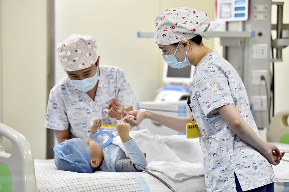在山東省棗莊市婦幼保健院兒童ICU病房，醫(yī)護(hù)人員為完成靶向治療藥物諾西那生鈉的4歲脊髓性肌萎縮癥患兒加油鼓勁（2022年1月1日攝）。諾西那生鈉注射液是我國(guó)首個(gè)獲批治療脊髓性肌萎縮癥的進(jìn)口藥物，2019年進(jìn)入中國(guó)市場(chǎng)時(shí)，每針價(jià)格近70萬元。在2021年國(guó)家醫(yī)保目錄藥品談判中，以3.3萬元每針的價(jià)格進(jìn)入新版醫(yī)保藥品目錄。新華社記者 郭緒雷 攝