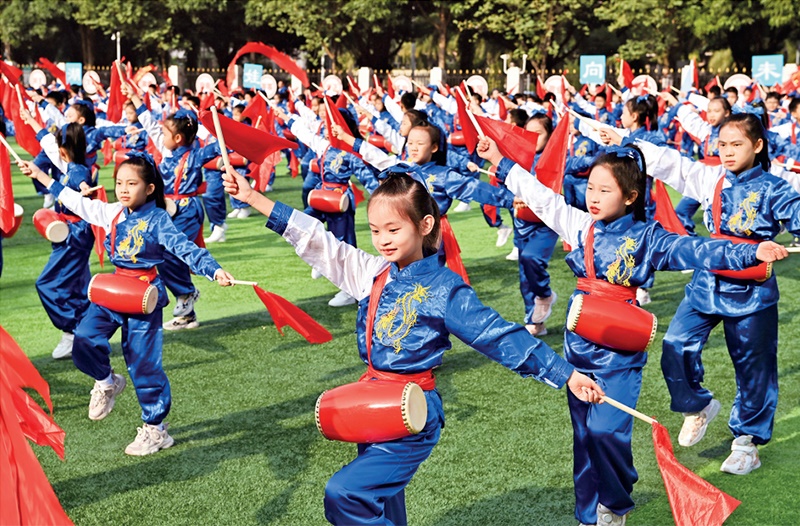 為助推民族地區(qū)基礎(chǔ)教育事業(yè)發(fā)展，廣西重新核定各地中小學(xué)教職工編制，依托全區(qū)編制“周轉(zhuǎn)池”核增事業(yè)編制給各地中小學(xué)，在全面達(dá)到國(guó)家標(biāo)準(zhǔn)的基礎(chǔ)上，進(jìn)一步統(tǒng)籌優(yōu)化和動(dòng)態(tài)調(diào)整各區(qū)域、學(xué)校、學(xué)段間編制資源。圖為2023年11月29日，南寧市濱湖路小學(xué)舉行主題為“逐夢(mèng)新時(shí)代 健體向未來(lái)”的體育文化節(jié)，孩子們正在跳腰鼓舞。 新華社記者 周華/攝
