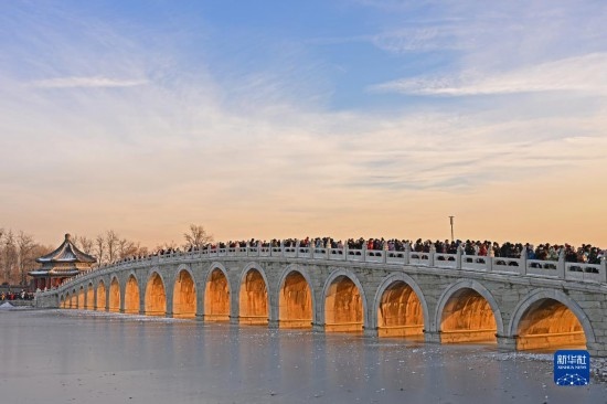 這是12月22日拍攝的頤和園十七孔橋“金光穿洞”景象。