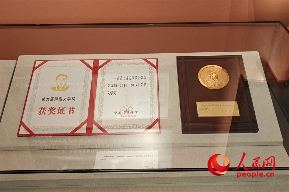 《這邊風景》獲得的第九屆茅盾文學獎證書與獎牌。人民網(wǎng)記者 韋衍行攝