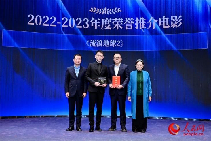 著名電影藝術(shù)家、事業(yè)家王曉棠（右一）和中國(guó)文聯(lián)書(shū)記處書(shū)記張宏（左一）為《流浪地球2》出品人、總監(jiān)制、總制片人傅若清（右二）與導(dǎo)演郭帆（左二）頒發(fā)“2022-2023年度榮譽(yù)推介電影”